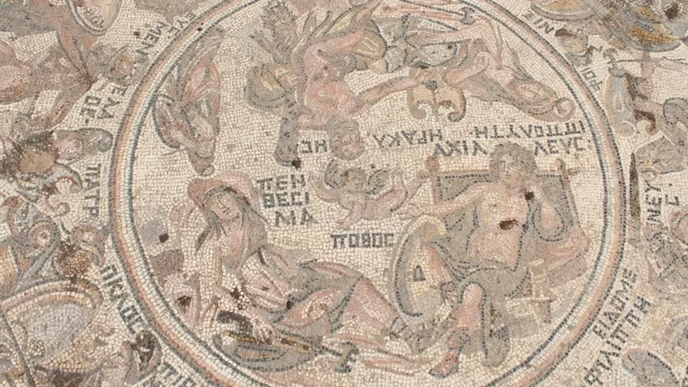 A roman mosaic depicts several figures along with descriptive roman text. But I don't know what it says because I can't read Latin.