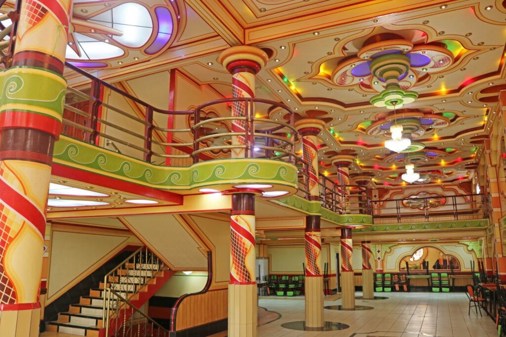 An interior of a building with high ceilings and brightly coloured geometric designs. 