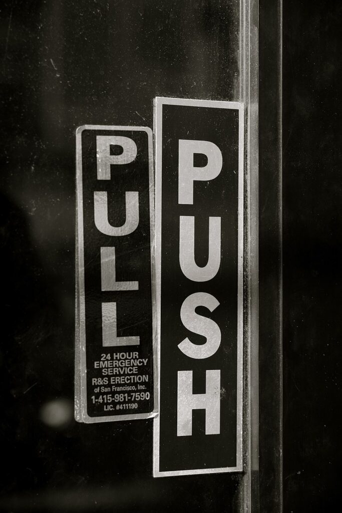 Stickers on a glass door read "Pull" and "Push."
