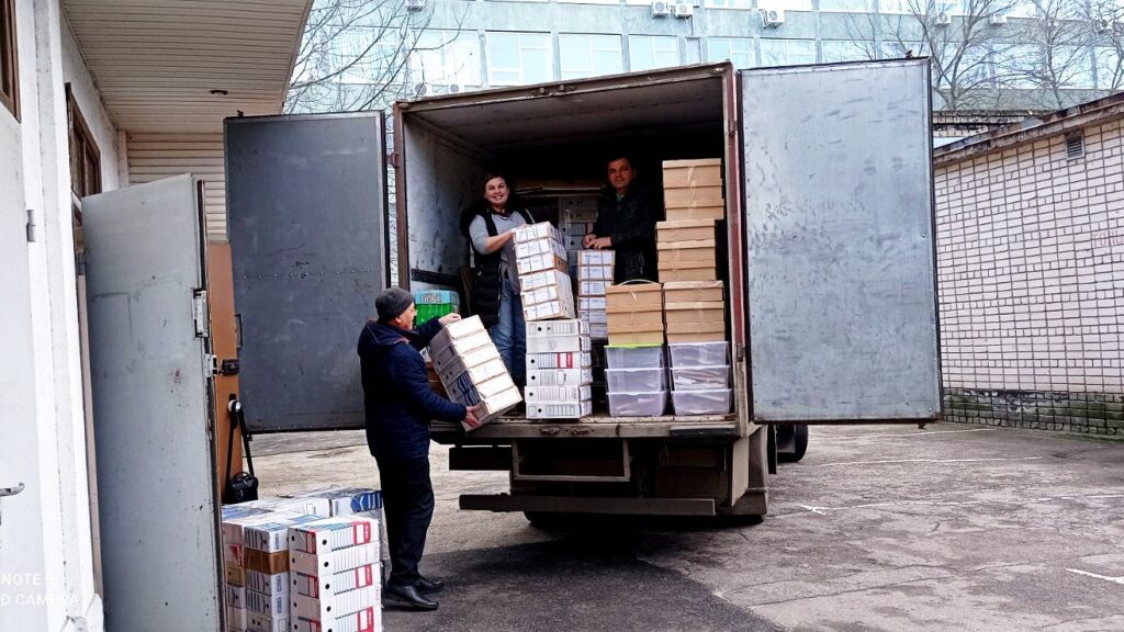 Scientists load boxes of herbarium samples into the back of a cube van.
