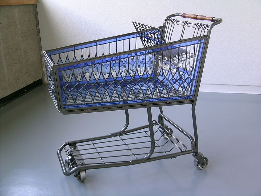 A grocery cart with the side panels made of blue stained glass. 